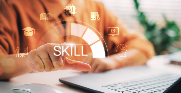 Close-up of a person sitting at a desk with a laptop, pointing at a glowing, semi-circular digital interface. The central text reads "SKILL" and is surrounded by floating icons representing education, AI, training, and learning.